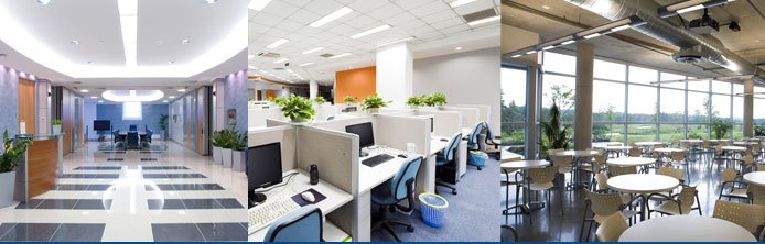 Modern office interior showcasing clean workspaces, cubicles with computers, and a bright, inviting meeting area with large windows and plants, emphasizing a tidy environment for productivity and client presence.