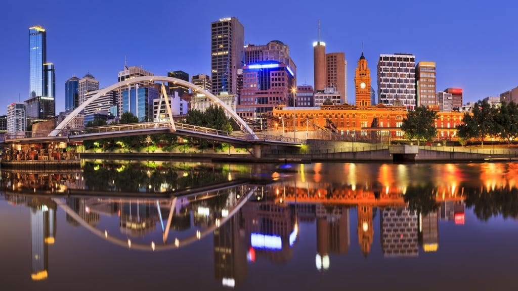 Melbourne city skyline at dusk with reflections on the Yarra River, showcasing iconic buildings and the bridge, representing the area served by Local Cleaning Services.